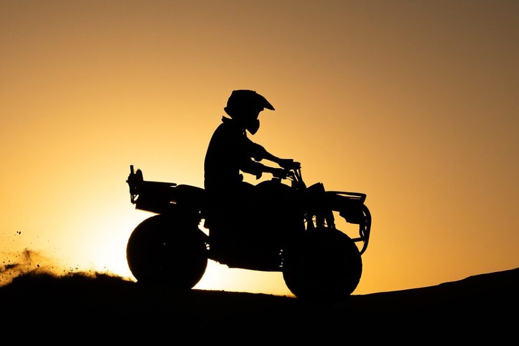 Silhouette d'un pilote de quad au coucher de soleil dans le désert d'Agafay, près de Marrakech